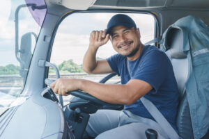 smiling truck driver in cab of truck